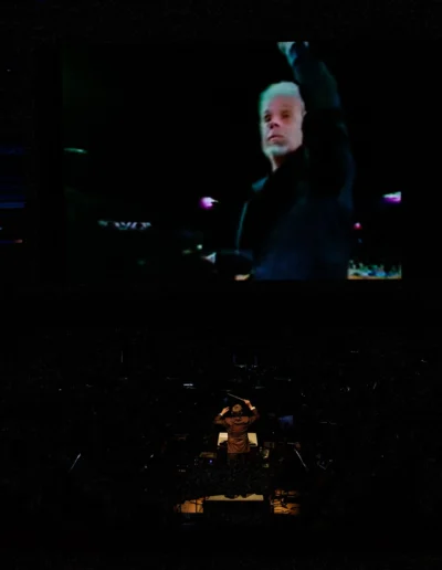 Carl Topilow conducting beneath a video of Peter Nero conducting.