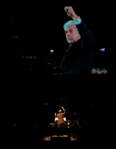 Carl Topilow conducting beneath a video of Peter Nero conducting.
